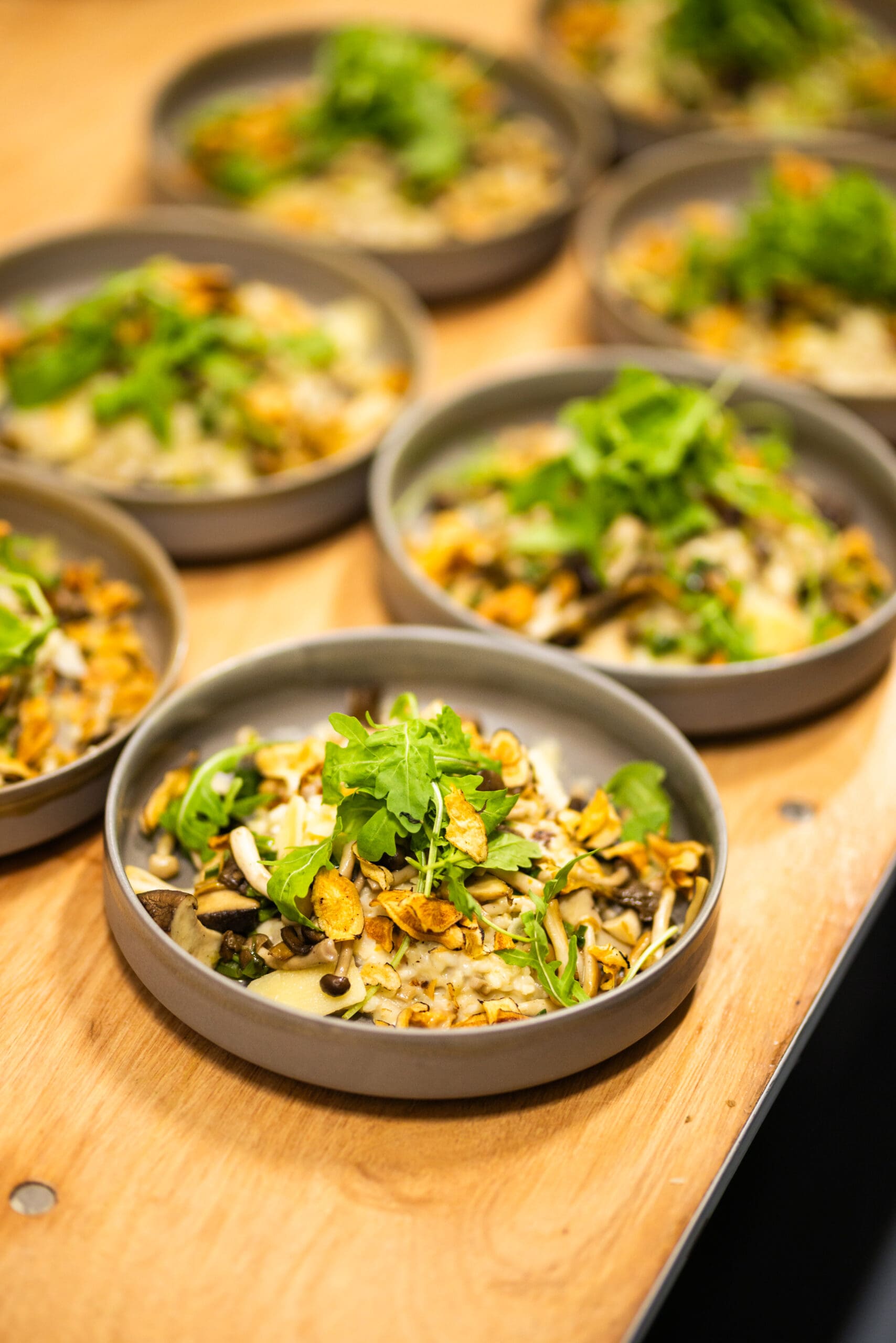 Foto van risotto met shitake en rucola sla, mooi gedresseerd, klaar om naar de zaal te vertrekken
