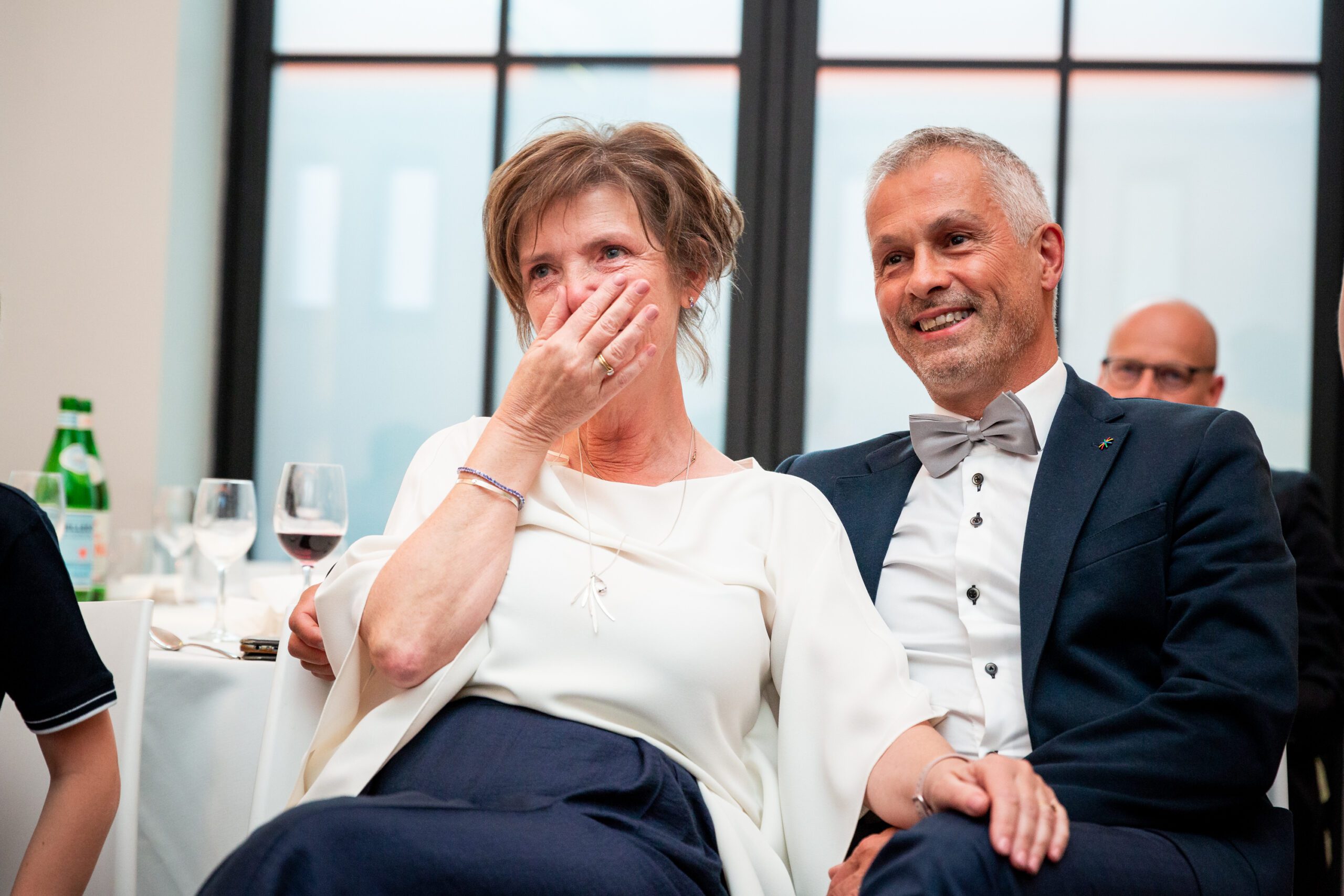 De vrouw zit vol ongeloof en vol emotie te kijken naar wat de gasten voor haar hebbe, voorbereid